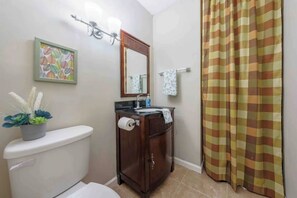 A bathroom with a toilet, sink, vanity, and a shower curtain. - Never wanna "LEAF" (Stone Mountain)