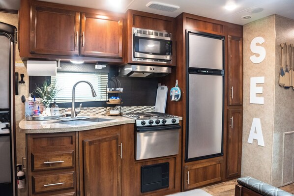 Enjoy cooking in this fully equipped kitchen with a microwave, stainless steel stove, and refrigerator.
