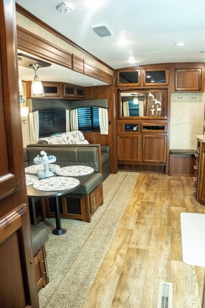 Enjoy a compact kitchenette, dining area, and seating space within this RV.