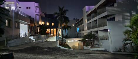 A modern building with multiple floors and balconies, featuring a central open area with a staircase leading to the upper levels.