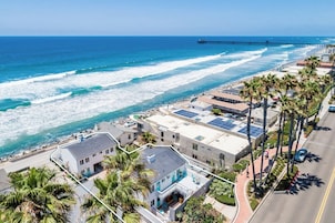 A coastal hotel with a view of the ocean and a pier.