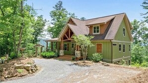 A two-story house with a green exterior, a stone foundation, and a wrap-around porch. - Private MNT Escape close to DuPont, Pisgah Forest, Brevard, Hendersonville. (Hendersonville)