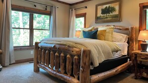 A bedroom with a large bed, wooden headboard, a ceiling fan, and a painting on the wall. - Private MNT Escape close to DuPont, Pisgah Forest, Brevard, Hendersonville. (Hendersonville)