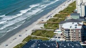 A coastal hotel with multiple buildings, a parking lot, and a beach in the background. - The Sea Cabin w/ Partial Ocean View & Pool, Golf, Beach (North Myrtle Beach)
