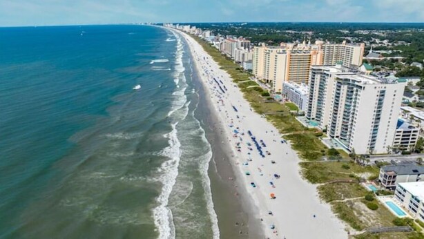 An aerial view of a beach with a row of high-rise buildings along the shore. - The Sea Cabin w/ Partial Ocean View & Pool, Golf, Beach (North Myrtle Beach)