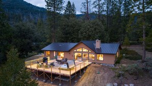 A cabin with a deck, large windows, and a chimney. - Mountain Retreat on 5 acres with nature views, deck, hot tub, EV charging (Mariposa)