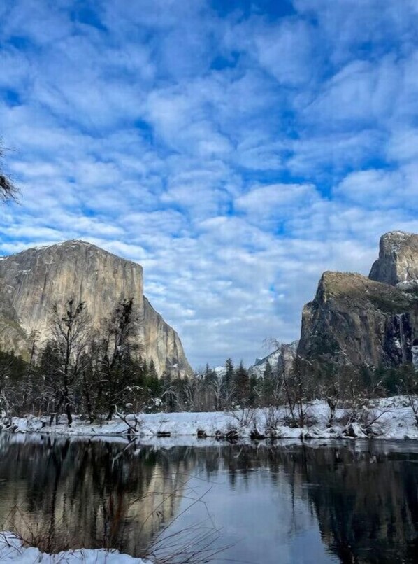 A natural landscape with a large rock formation and a calm body of water reflecting the sky. - Mountain Retreat on 5 acres with nature views, deck, hot tub, EV charging (Mariposa)
