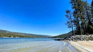 A beach with clear water, a sandy shore, and a forested hillside in the background. - Mountain Retreat on 5 acres with nature views, deck, hot tub, EV charging (Mariposa)