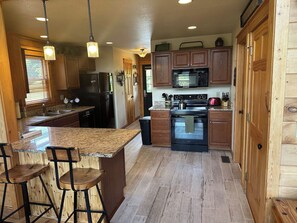 A kitchen with wooden cabinets, a granite countertop, and a built-in oven.