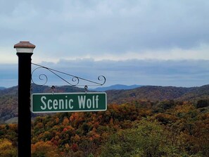 A street sign reading "Scenic Wolf" against a backdrop of autumn foliage and mountains. - Wildlife Ridge-Views, Gameroom, Hot Tub 4300' Elev (Mars Hill)