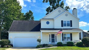 A two-story house with a garage, a front porch, and an American flag. - ☘️ 10 mins to Notre Dame, 4 Bedrooms, Garage Park, Restaurants Close. Go Irish!☘️ (South Bend)