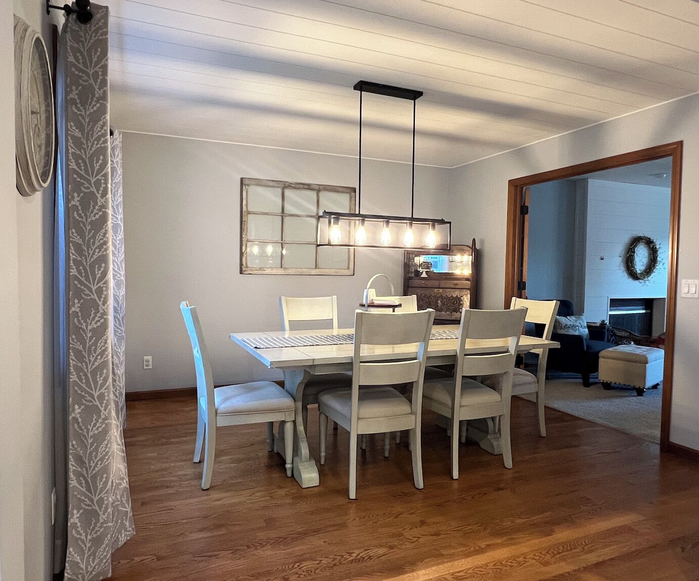 Un espace repas comprenant une table et des chaises, un luminaire suspendu et un appliques murales.