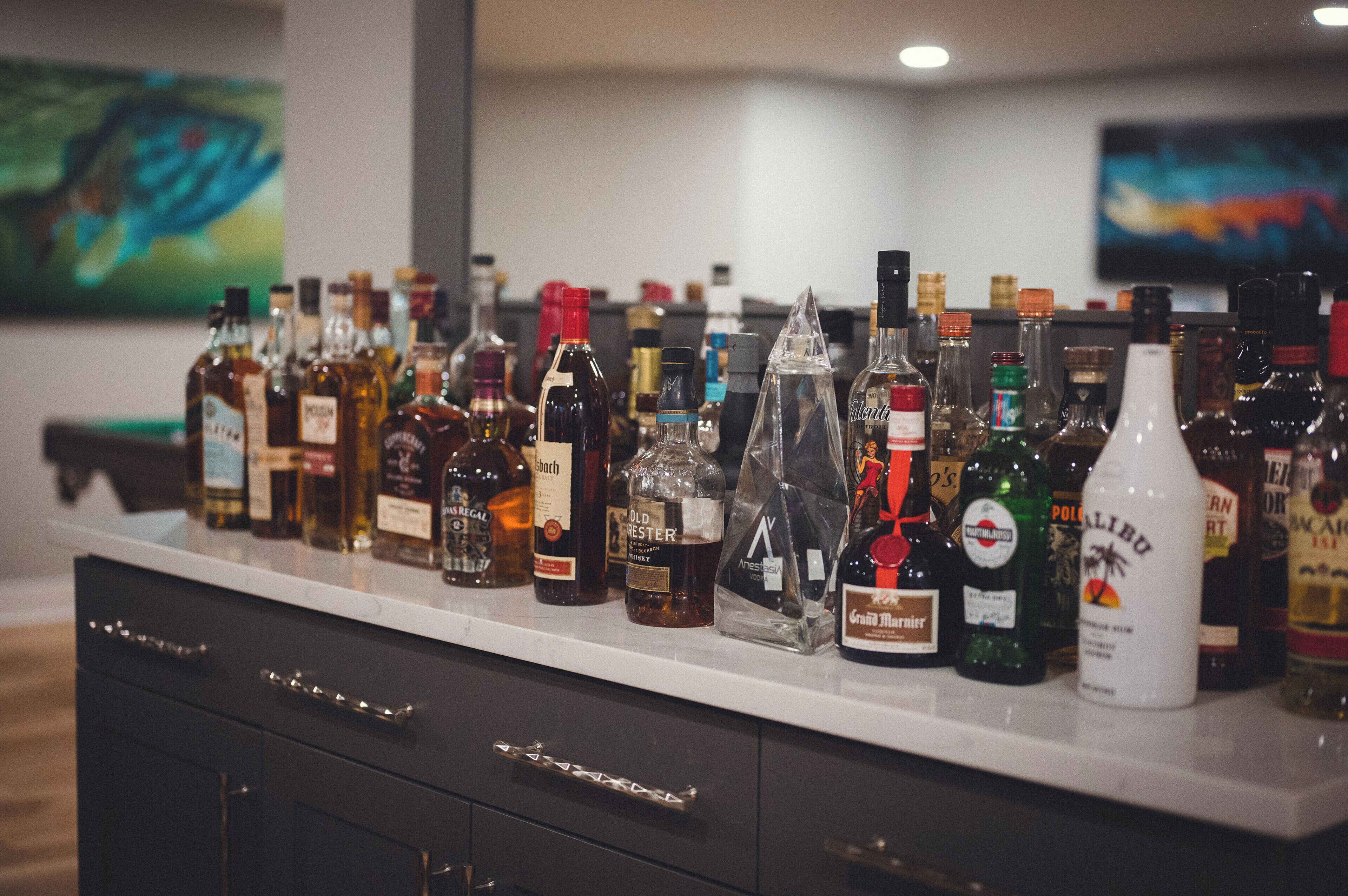 Una zona de bar con una variedad de botellas de licores a la vista.