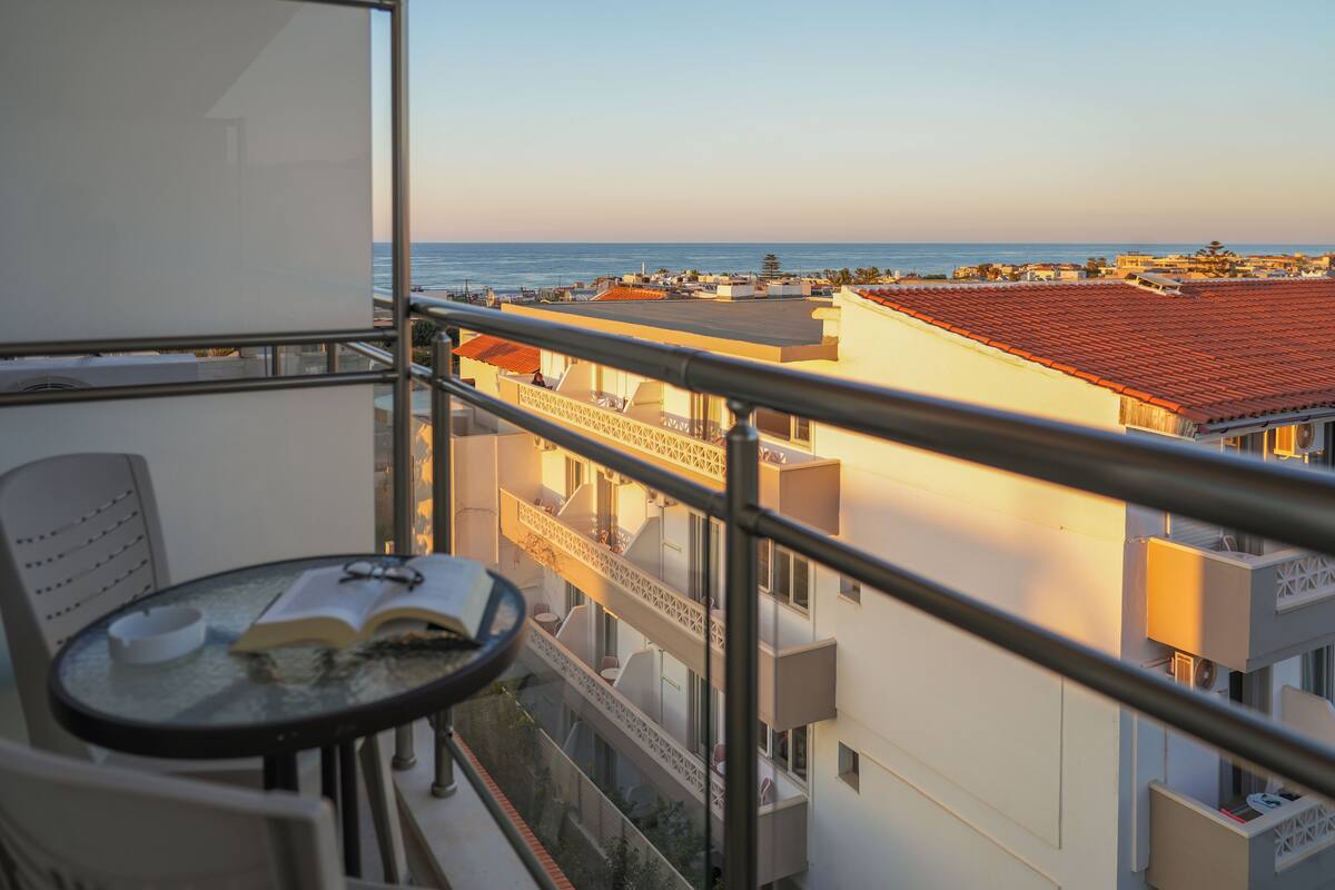 A balcony with a table, chairs, and an open book.