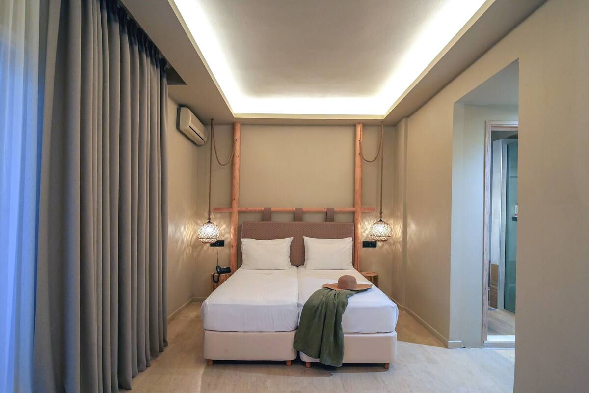 A modern bedroom with a large bed, a wooden headboard, and two bedside lamps.