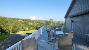 A deck with outdoor furniture, a railing, and a view of a green landscape. - Hillside Relaxation in Endless Mountains. Minutes from Tioga Downs. Sleeps 8 (Rome)
