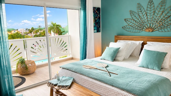 A bedroom with a bed, a view of the outside, and a decorative wall piece.