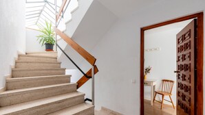 Una scala con ringhiera in legno che conduce a una stanza con zona pranzo e una porta con decoro.