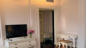 A hotel room with a bed, a TV, a desk with drawers, a chair, and a small table. - Hanoi Memory Central Hotel & Spa (Hanoi)