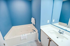Un bagno con una vasca, un lavandino e uno specchio.