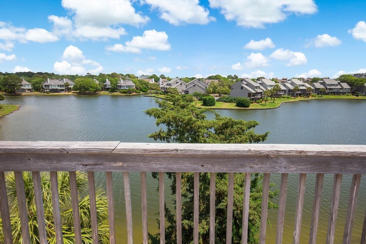 A lakeside view of a residential area with houses and a wooden deck in the foreground.