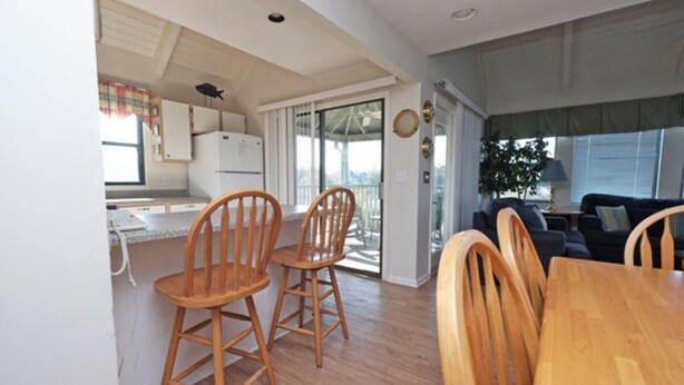 Un espacio habitable compacto con cocina, comedor y balcón con vistas.