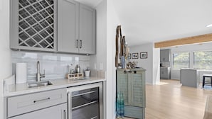 A modern kitchen with grey cabinets, a stainless steel sink, and a built-in oven.