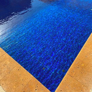 A clear blue pool with a wooden border.