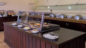 A buffet setup with multiple food stations, including a hot food station and a cold food station, with bowls and utensils on the counter. - ALTAVISTA (Reynosa)