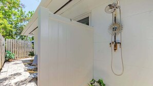 A white house with a covered patio, a wooden fence, and a shower with a sunburst design. - Siesta Keys Neighbor 5min to Beach - Entire Suite Apartment (Sarasota)