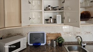 A kitchen with a microwave, a glass display case, and a sink. - Visita LA Villa Medieval DE Allariz ! Alojate EN Casa Lina (Allariz)