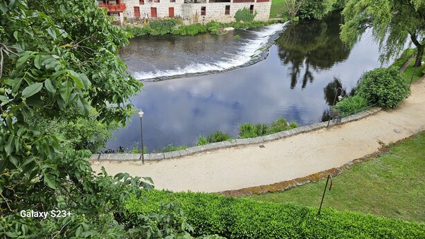 A riverside view with a stone building, a paved walkway, and lush greenery. - Visita LA Villa Medieval DE Allariz ! Alojate EN Casa Lina (Allariz)