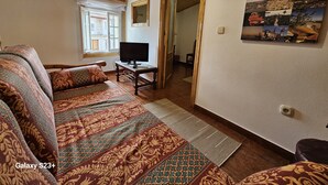 A cozy room with a Galaxy S23+ on a wooden table, patterned rugs, and a wall with a collage of images. - Visita LA Villa Medieval DE Allariz ! Alojate EN Casa Lina (Allariz)