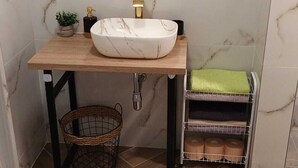 A bathroom with a marble sink, a toilet, a mirror, and a towel rack. - New modern 3-bedroom apartment with AC in Supetar (Selca)