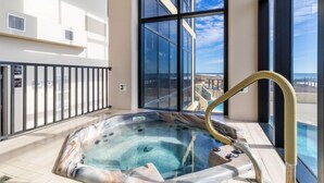 Un jacuzzi en un balcón con vista al mar.