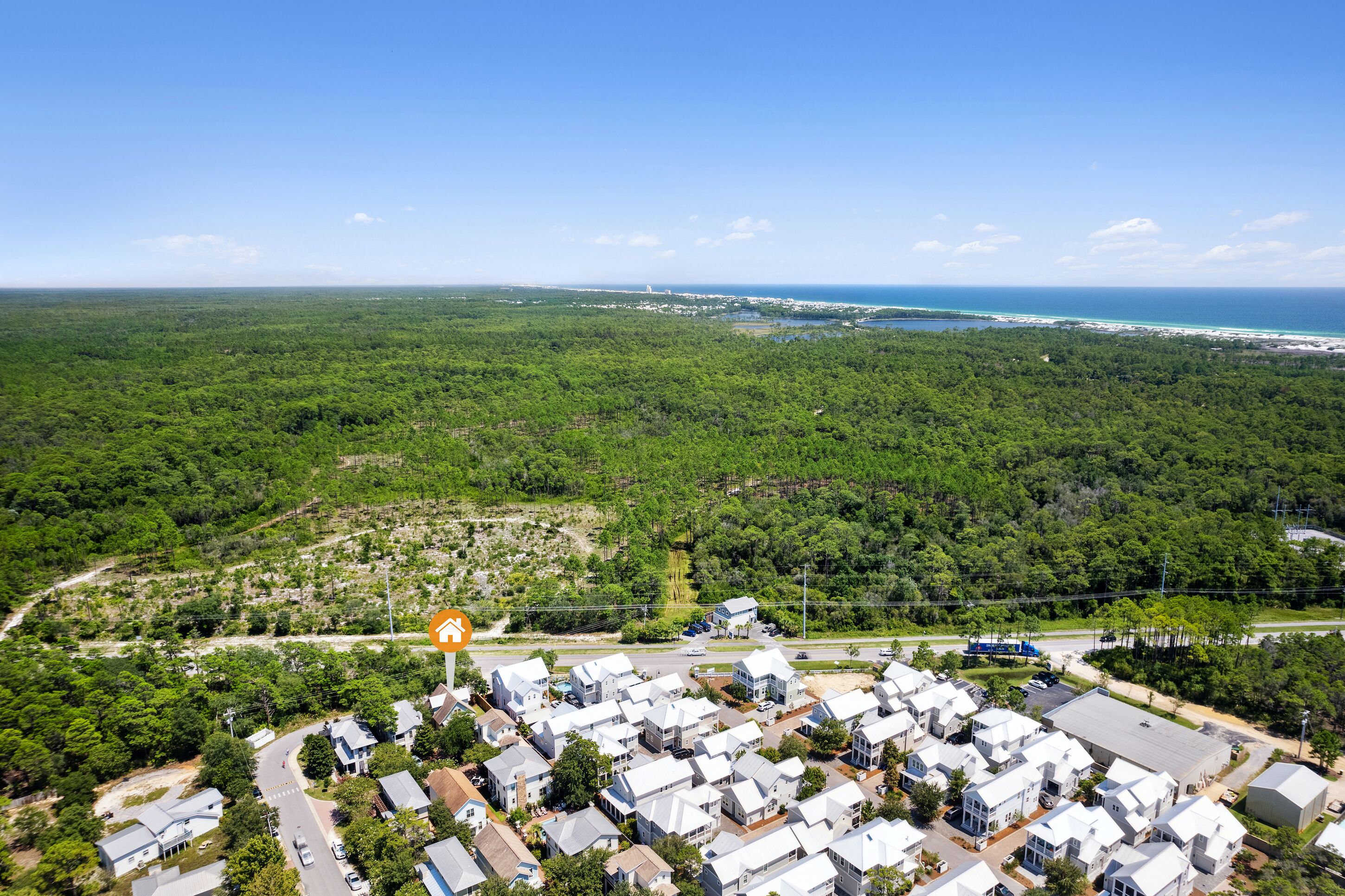 Vista aérea de una zona residencial con casas, carreteras y una costa.