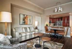 A modern living room with a sofa, coffee table, and a dining area with chairs and a table. - Las Vegas | Pool & Strip Access | Metro Escape Stay (Las Vegas)