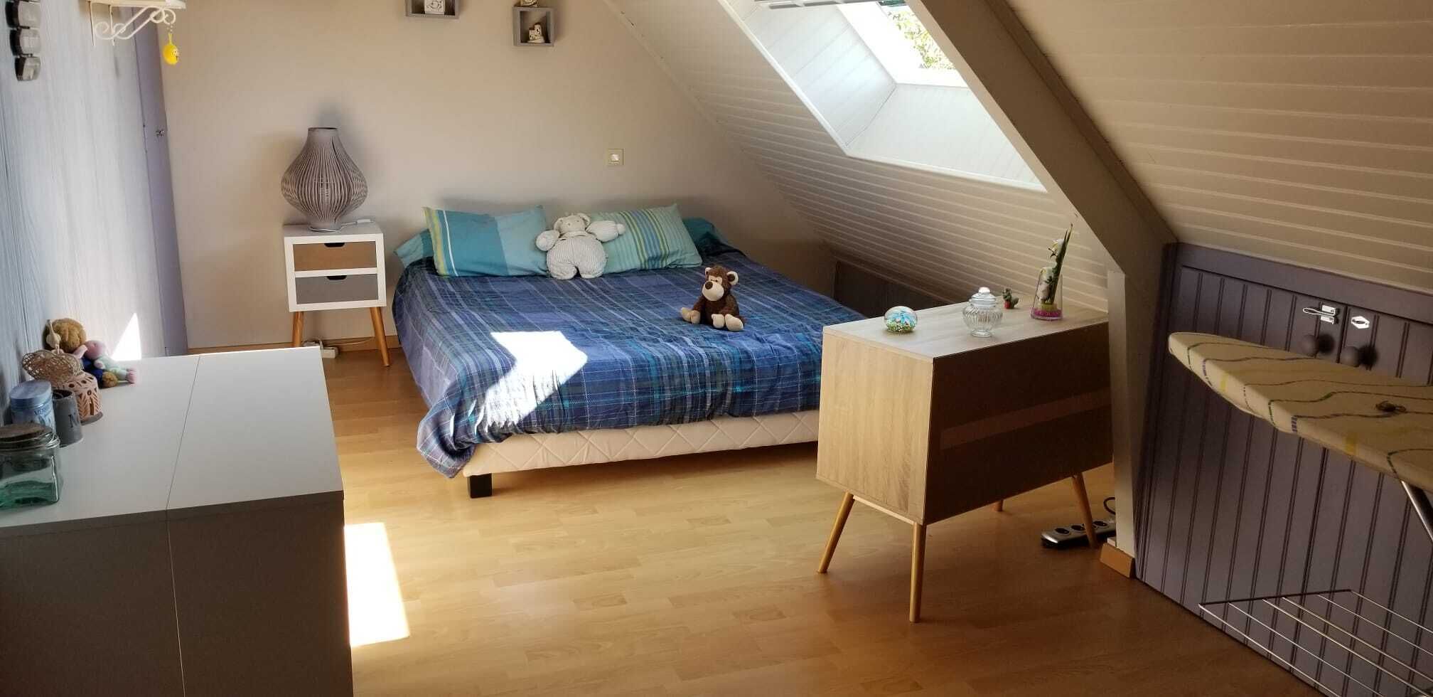 Une chambre confortable avec un lit, un bureau et une fenêtre de toit.
