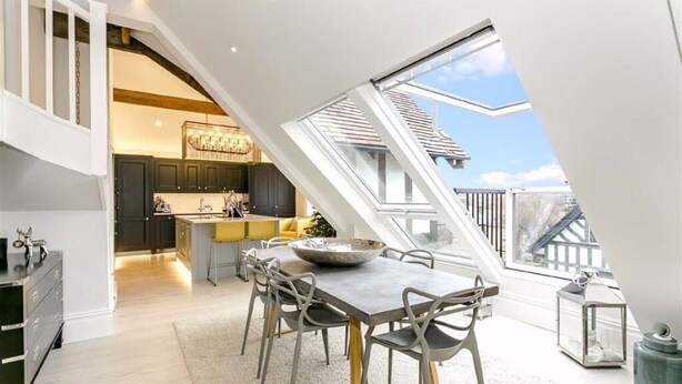 A dining area with a high ceiling and skylight, a kitchen with dark cabinets, and a view of the outside. - Executive 3 bedroom Penthouse apartment, 2 bath and Mezzanine (Harrogate)
