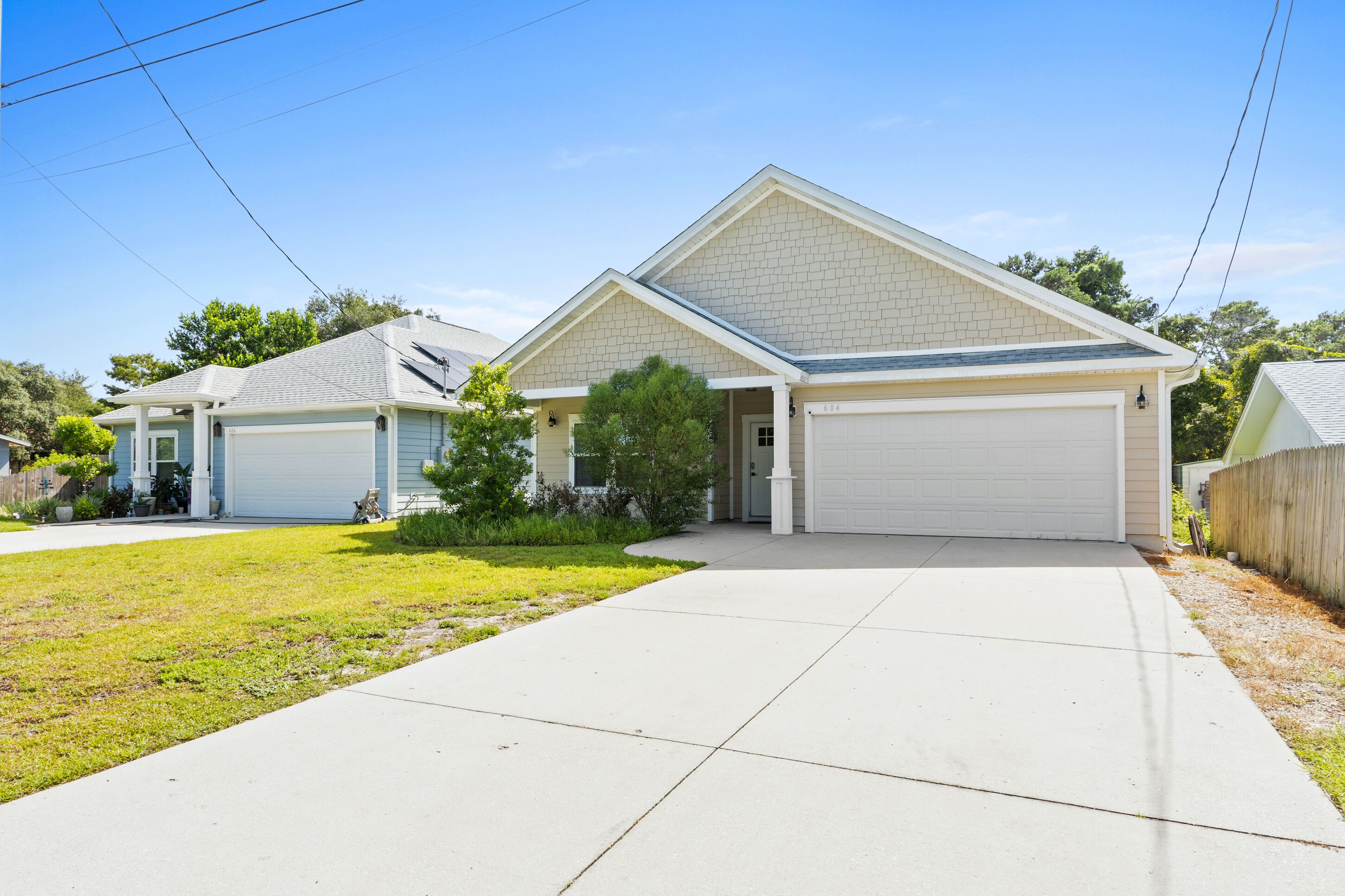 A two-story house with a garage, a covered driveway, and a small front yard.