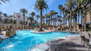 A pool area with palm trees, lounge chairs, and a clear blue pool. - Las Vegas | Pool & Strip Access | Modern Vegas Stay (Las Vegas)