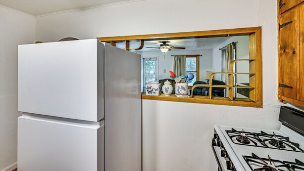 A kitchen with a refrigerator, stove, and a wooden cabinet. - Peaceful Grams Lake Stay Near Notre Dame (New Carlisle)