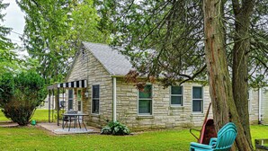 A stone house with a porch, a table, and a bench. - Peaceful Grams Lake Stay Near Notre Dame (New Carlisle)