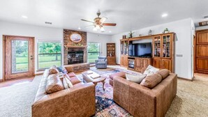 A spacious living room with a fireplace, a large TV, and a cozy seating area.