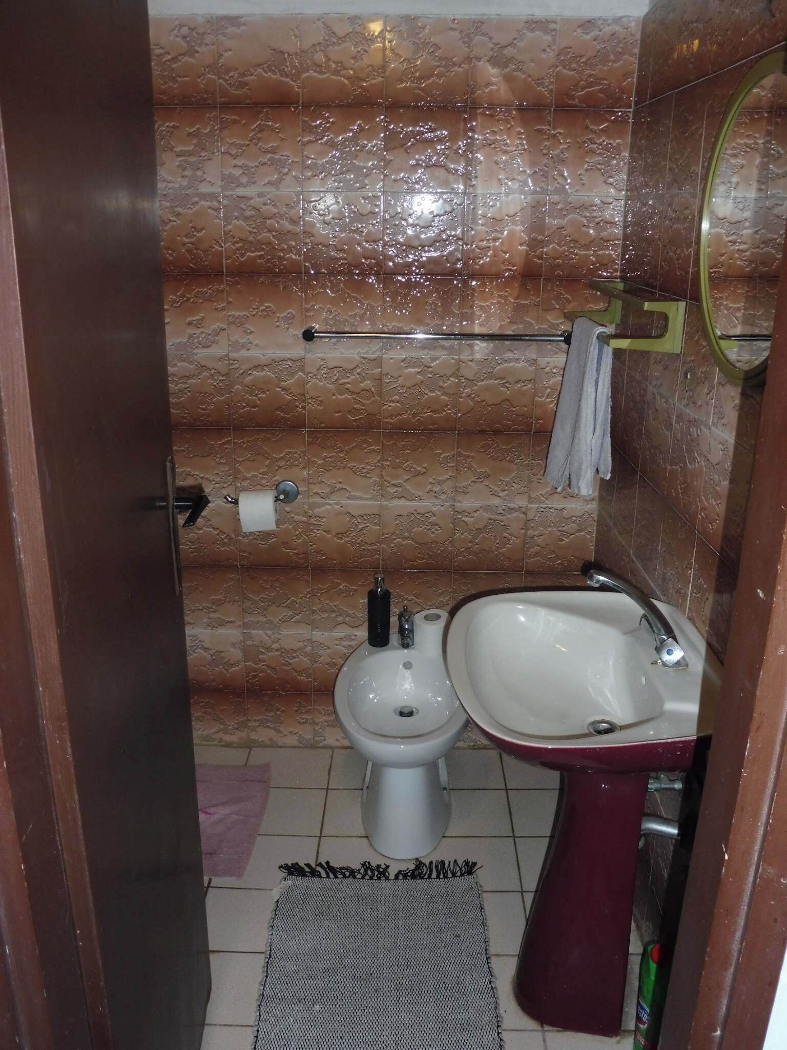 Un baño con inodoro, bidé y lavamanos.