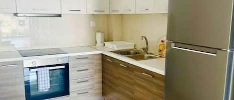 Een koelkast, een magnetron, een oven, eettafels