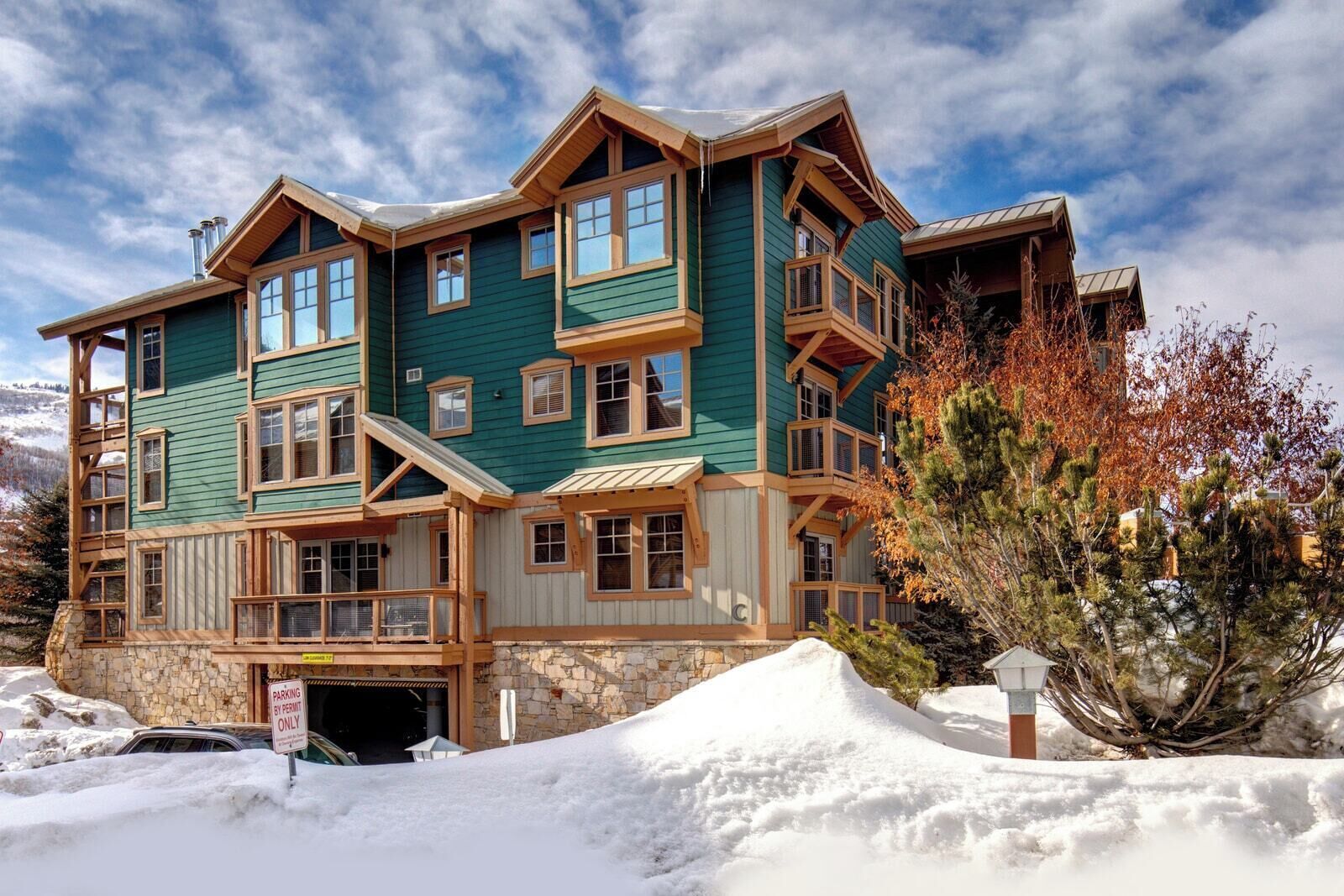 A multi-story lodge with a stone foundation, large windows, and a prominent entrance.