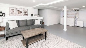 A modern living room with a grey sofa, a wooden coffee table, and a patterned rug. - Salisbury Hideaway (Salisbury)