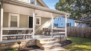 A house with a covered porch, outdoor seating, and a stone foundation. - Salisbury Hideaway (Salisbury)