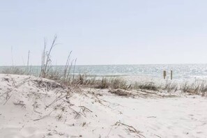 En strand med sanddyner och fri utsikt över havet.